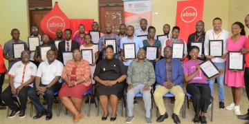 Absa Bank Uganda's Ag. Head of Markets Catherine Kijjagulwe (in maroon dress), with Makerere University officials and journalists after the masterclass