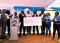 Walter Wafula,(4th R),CEO Fireworks Advertising hands over a dummy check to Dr. Victor Odongo,(5th L),Board President CoRSU Hospital at the CoRSU walk launch 2025