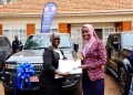 Lady Justice, Jane Frances Abodo handing over the car documents to Mrs. Janat Kitimbo, one of the beneficiaries.