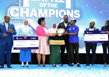 Sarah Kagingo, the Vice Board Chairperson of Private Sector Foundation handing a shield of excellence to Sumaya Girls patron teacher.