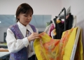 Magauia Yrsbek reviews her new material, blending silk and felt. [Photo courtesy of Magauia Yrsbek]