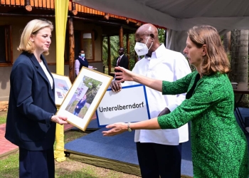 Austria's Foreign Affairs Minister Beate Meinl-Reisinger (L) showing President Museveni some historical photos from Austria during a meeting on the sidelines of the NAM Ministerial meeting at Munyonyo on We