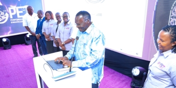 Chief Justice Alfonse Owiny Dollo testing the PET tool at the Go live event on Friday as other Judicial staff look on.