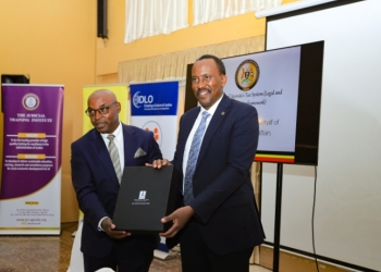 Deputy Chief Justice, Dr. Flavian Zeija receiving a token of appreciation from URA Commissioner, John Musinguzi Rujooki at the opening of the training on Monday.