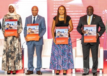 Minister of State for National Guidance Godfrey Kabbyanga, left, displays a copy of the GSMA report with Dr. Aminah Zawedde, Permanent Secretary for the Ministry of ICT and National Guidance, GSMA Head of Africa Angela Wamola, and Uganda Communications Commission Executive Director George William Nyombi Thembo at the report launch Monday in Kampala, Uganda. The report calls for tax reforms and policy changes to boost digital inclusion.