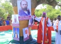 Archbishop Rt Rev Stephen Kazimba Mugalu standing next to Bishop Hanington's Portrait.