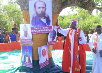 Archbishop Rt Rev Stephen Kazimba Mugalu standing next to Bishop Hanington's Portrait.