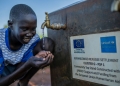 Eleven-year-old Laul Marol drinks clean water from a tap stand in Cluster I, Kiryandongo Refugee Settlement, on October 14, 2025. The facility was installed by UNICEF with support from European Union Humanitarian Aid. Throughout the settlement, children like Marol are drawn to the sound of flowing water. They gather at the tap stands to drink, rinse their faces, and wash away the day's dust from their legs, their laughter filling the air. These everyday moments of childhood made possible by reliable access to safe water, represent a fundamental shift in daily life across the camp. © UNICEF/UNI881276/Bamulanzeki