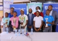 Stanbic Bank's Head of Affluent Banking Arthur Kiwanuka (in tie-centre), and other stakeholders posing for a photo with some of the junior players during the launch of the Stanbic Annual Junior Golf Championship on Thursday