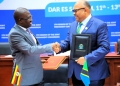 Uganda Minister of State for Foreign Affairs John Mulimba, left, and Tanzania Foreign Minister Mahmoud Thabit Kombo exchange signed copies of a joint communique at the conclusion of the fifth session of the Joint Permanent Commission in Dar es Salaam on Friday, March 13, 2026. The agreement sets a June 30 deadline to eliminate non-tariff barriers and fast-track regional energy and infrastructure projects.
